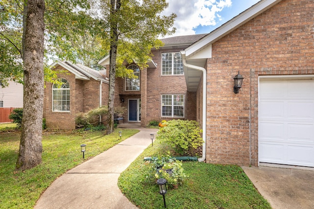 view of property with a garage and a front lawn