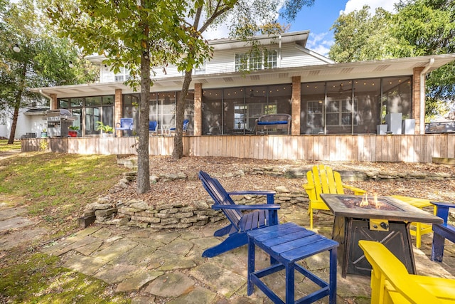 view of patio / terrace featuring an outdoor fire pit and a sunroom