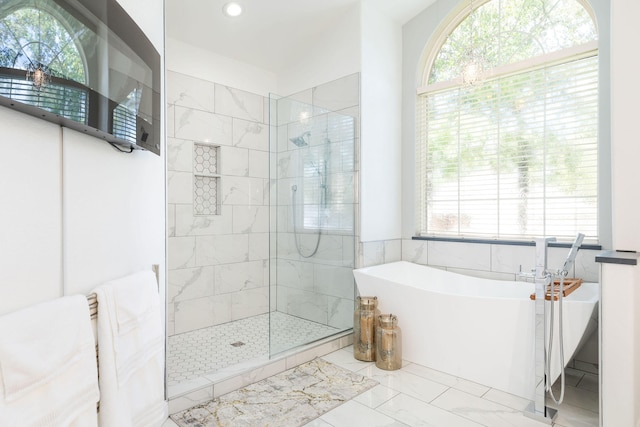 bathroom featuring separate shower and tub and a wealth of natural light