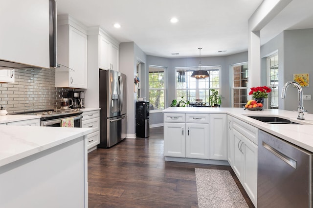 kitchen with white cabinets, sink, dark wood-type flooring, stainless steel appliances, and light stone countertops