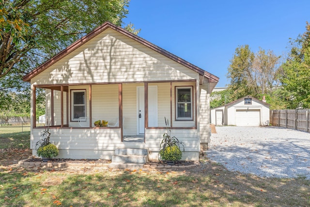 bungalow-style home with an outbuilding, a porch, and a garage