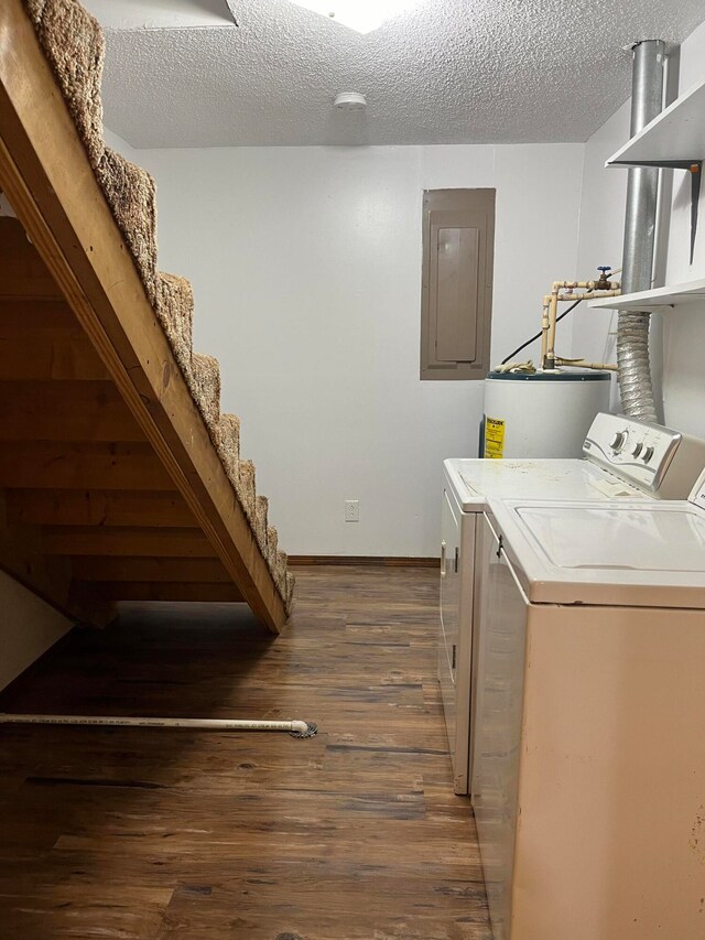 laundry area with electric panel, a textured ceiling, water heater, dark wood-type flooring, and washer and clothes dryer