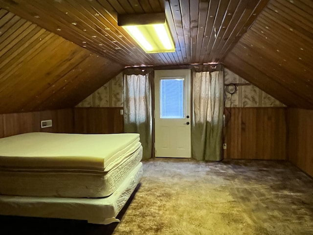 unfurnished bedroom with wood ceiling, carpet floors, wooden walls, and vaulted ceiling