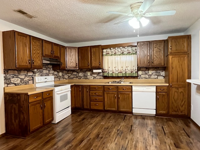 kitchen with white appliances, a textured ceiling, dark wood-type flooring, and sink