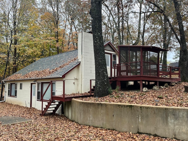 view of side of property featuring a wooden deck and a sunroom