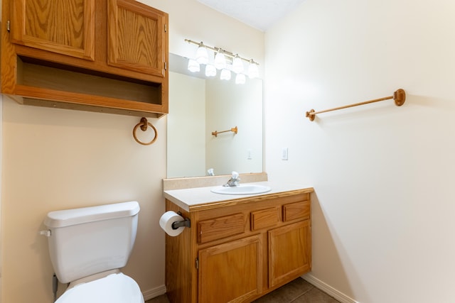 bathroom with tile patterned flooring, vanity, and toilet