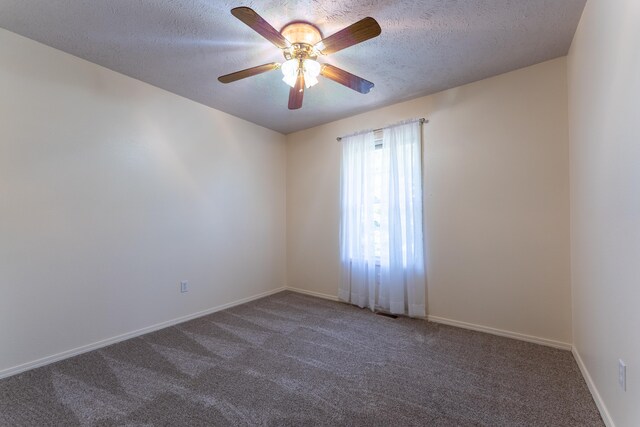 empty room with dark carpet and a textured ceiling