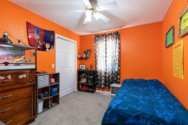 bedroom featuring ceiling fan, light colored carpet, and a textured ceiling