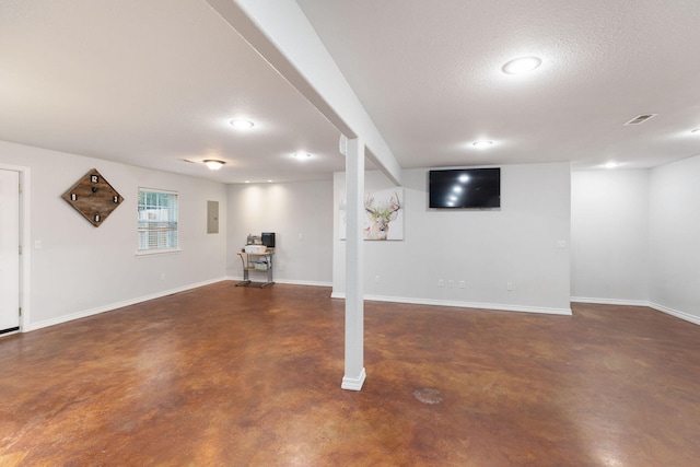 basement with a textured ceiling and electric panel