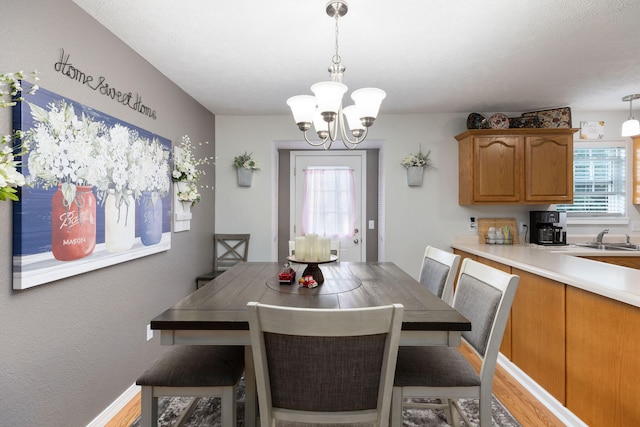 dining room with sink, hardwood / wood-style floors, and a notable chandelier