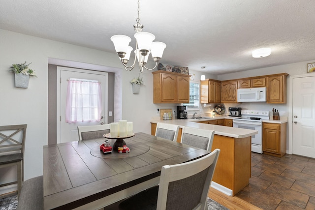 dining room featuring a textured ceiling, a notable chandelier, and sink