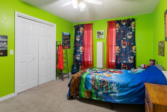 bedroom with ceiling fan, carpet floors, a textured ceiling, and a closet