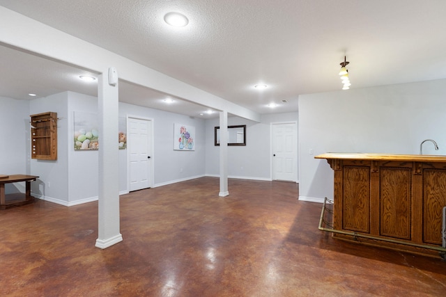 basement featuring a textured ceiling and sink