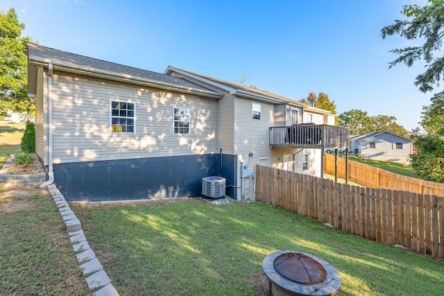 exterior space with central AC, an outdoor fire pit, and a lawn