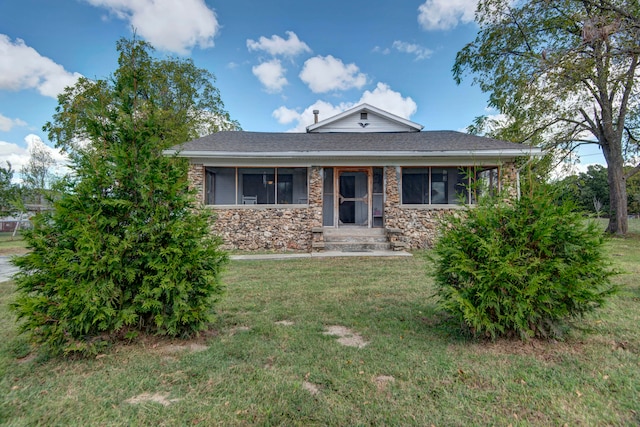 view of front of property with a front yard and a sunroom