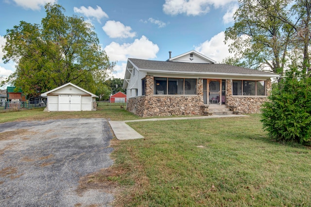 view of front facade featuring a garage, a front lawn, and an outbuilding