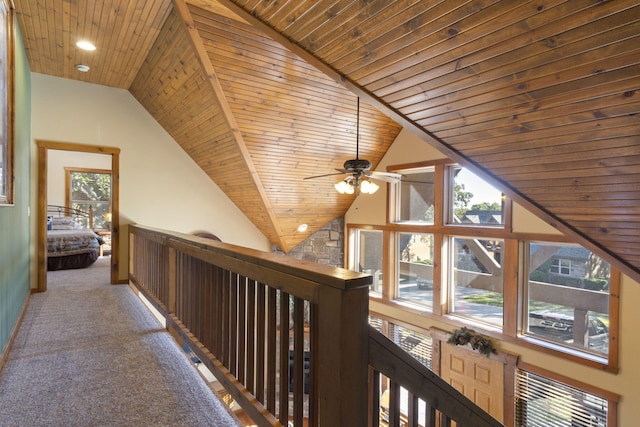 corridor with lofted ceiling, wood ceiling, and carpet