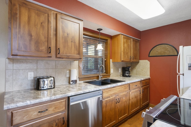 kitchen with white refrigerator, hardwood / wood-style floors, sink, backsplash, and stainless steel dishwasher