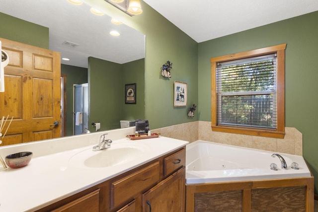 full bathroom featuring toilet, vanity, and independent shower and bath