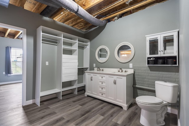 bathroom with wood-type flooring, vanity, beam ceiling, and toilet