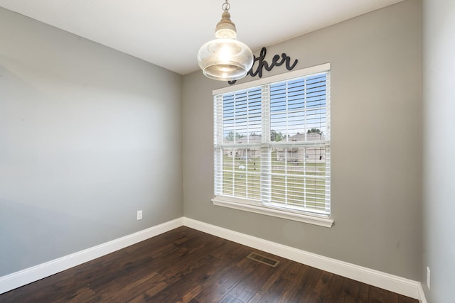 unfurnished dining area with dark wood finished floors, baseboards, and visible vents