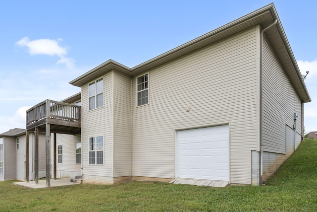 rear view of house with a lawn, a deck, and a garage