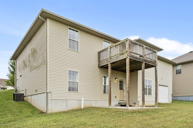 back of property with central AC, a garage, entry steps, a lawn, and a deck