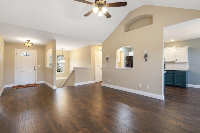 unfurnished living room featuring dark wood-type flooring, high vaulted ceiling, a ceiling fan, and baseboards