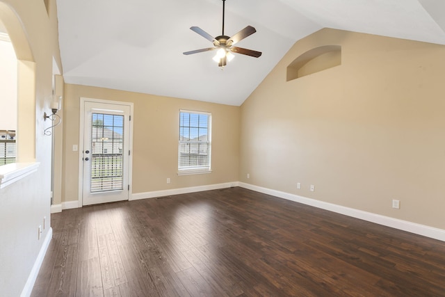 empty room with high vaulted ceiling, dark wood-style flooring, a ceiling fan, and baseboards