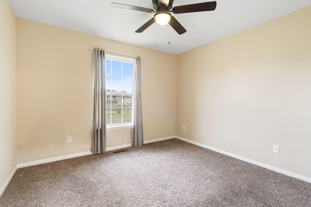 empty room with visible vents, carpet flooring, baseboards, and a ceiling fan