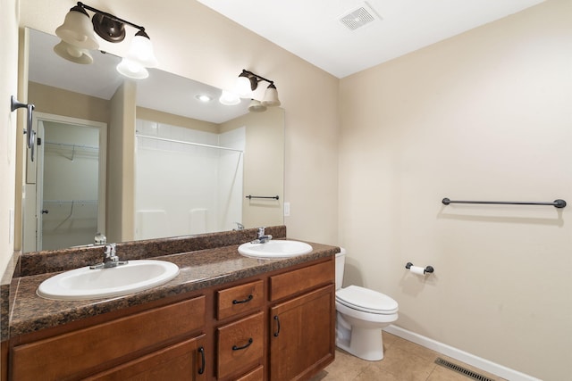 bathroom featuring tile patterned flooring, a shower, vanity, and toilet