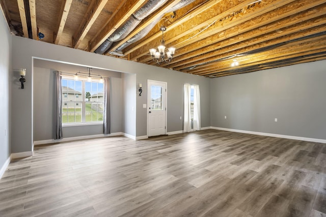 interior space featuring wood finished floors, a wealth of natural light, and a chandelier