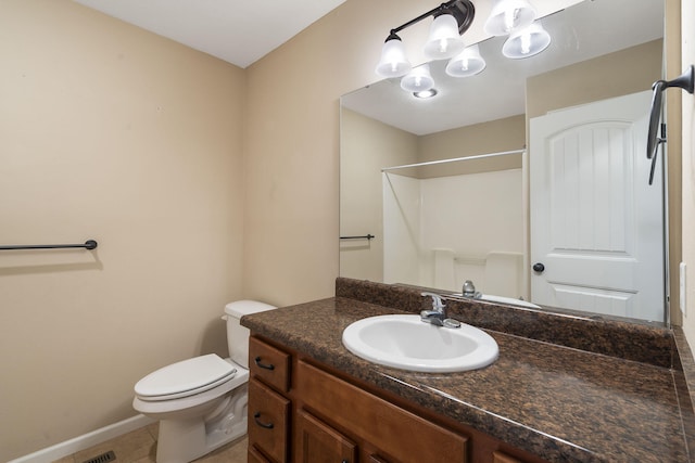 bathroom featuring vanity, walk in shower, baseboards, toilet, and tile patterned flooring