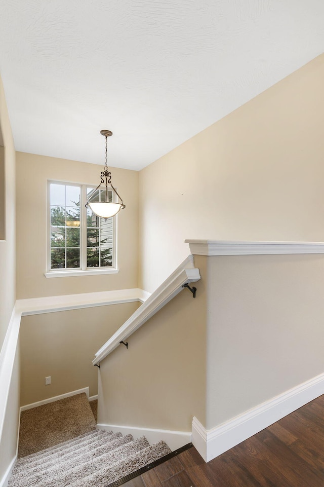 staircase with wood finished floors and baseboards