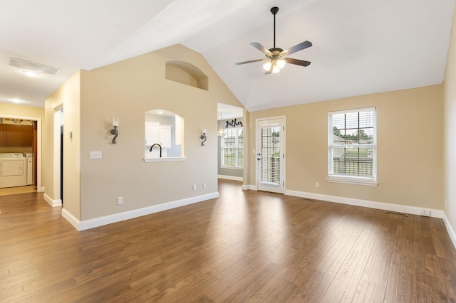 unfurnished living room featuring lofted ceiling, washer and clothes dryer, wood finished floors, visible vents, and ceiling fan