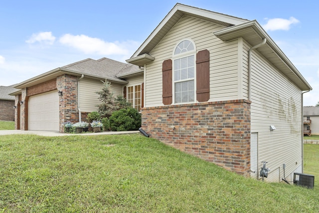 single story home featuring an attached garage, driveway, a front lawn, and brick siding