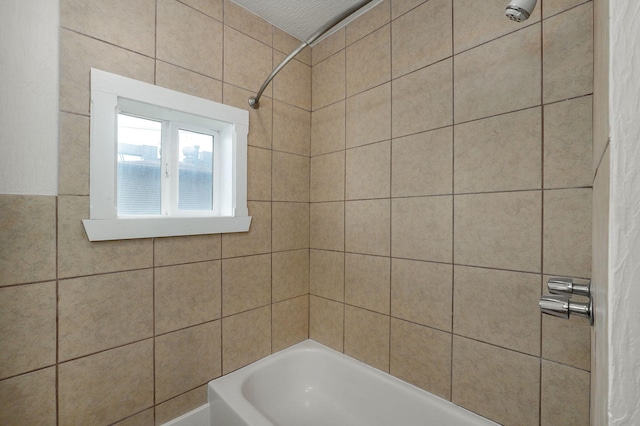 bathroom featuring tiled shower / bath