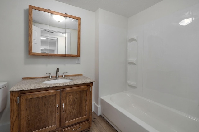 full bathroom with vanity, hardwood / wood-style floors, bathtub / shower combination, and toilet