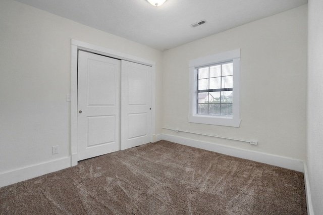 unfurnished bedroom featuring carpet and a closet