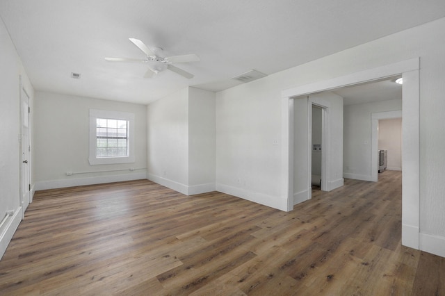 empty room with dark hardwood / wood-style flooring and ceiling fan