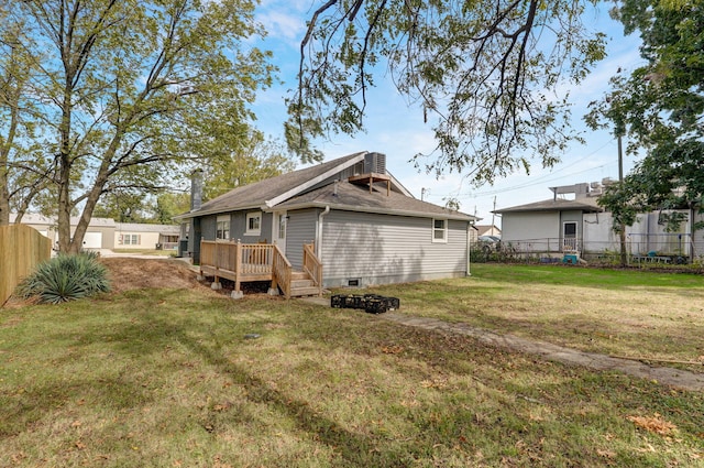 back of house with a wooden deck and a yard