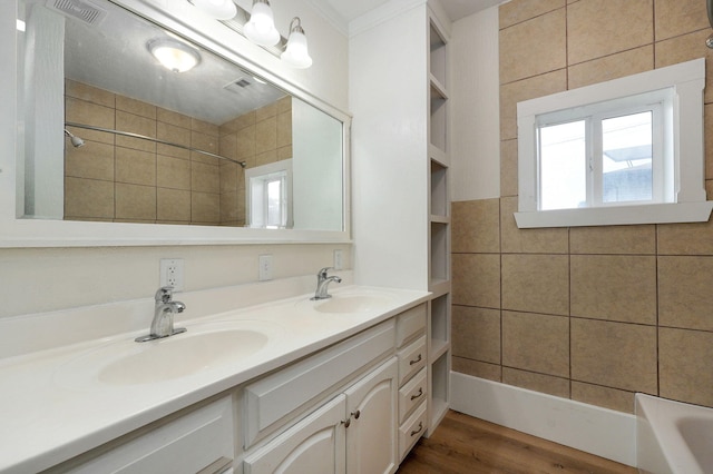 bathroom with tiled shower / bath, vanity, and wood-type flooring