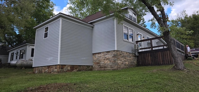 view of side of property with a deck and a lawn