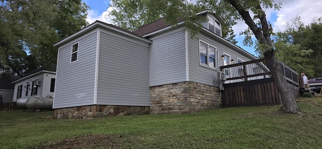 view of side of home with a lawn and a wooden deck