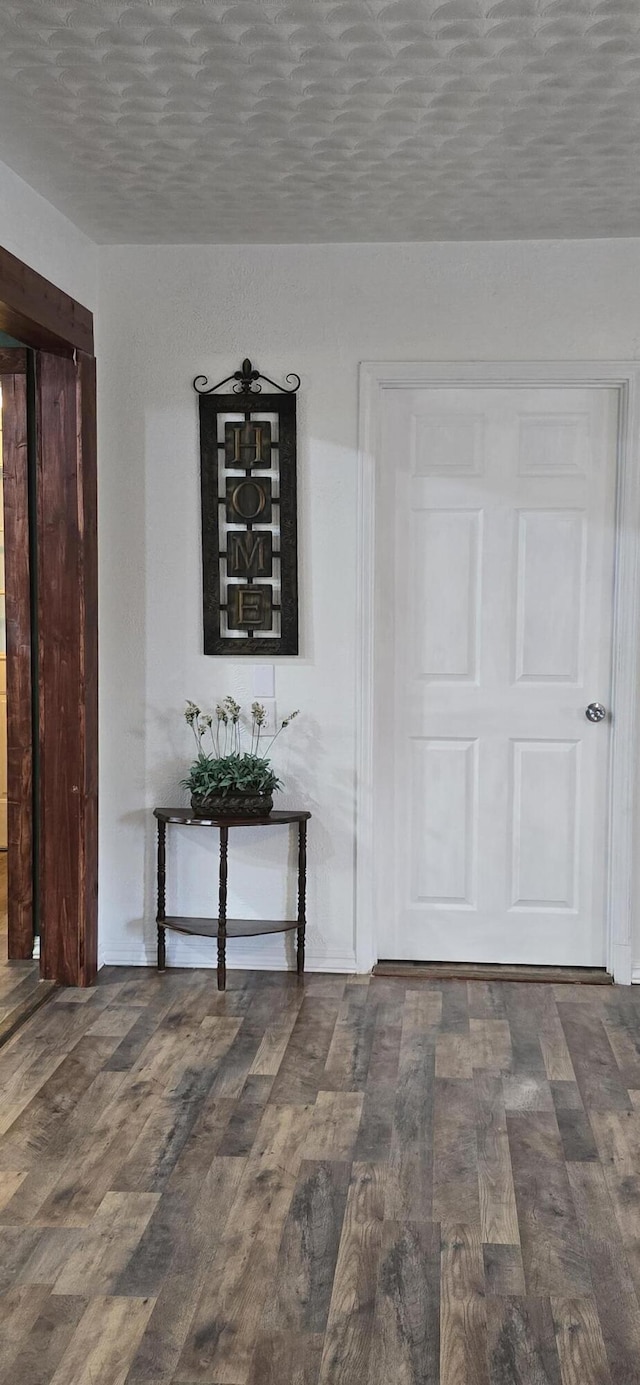 hall featuring wood finished floors and a textured ceiling