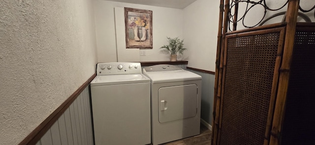 laundry room with independent washer and dryer and a textured wall