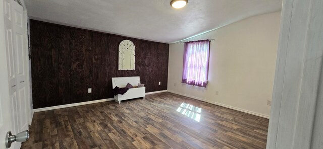 empty room featuring dark hardwood / wood-style flooring and lofted ceiling