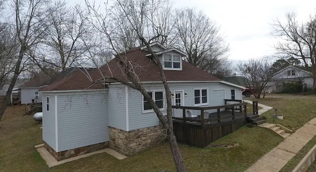 back of property featuring a wooden deck and a yard