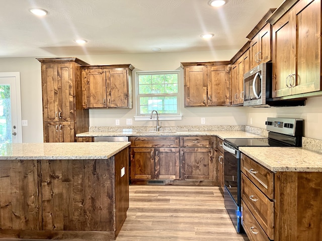 502 James, Billings, MO 65610 - kitchen featuring stainless steel appliances, a sink, recessed lighting, light wood-style floors, and light stone counters
