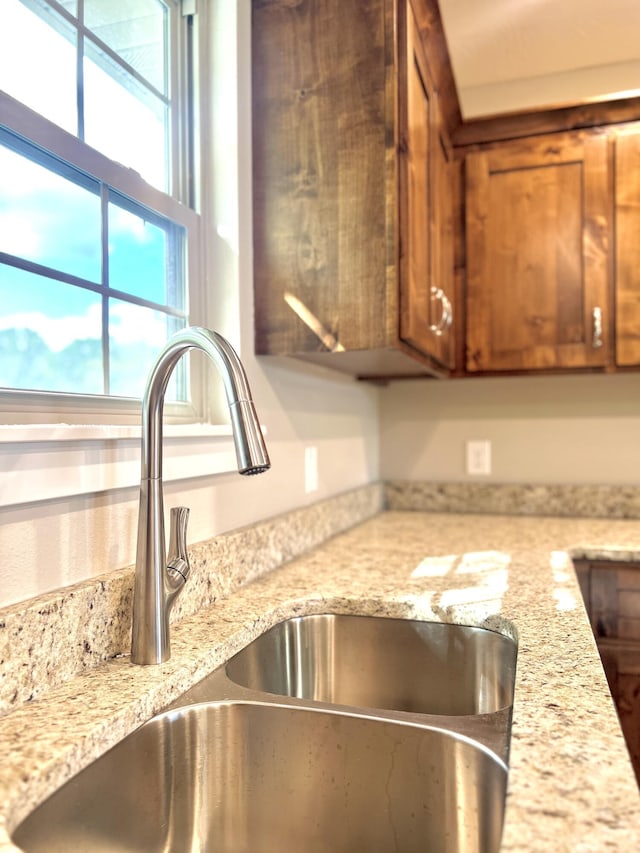 502 James, Billings, MO 65610 - details with a sink, brown cabinets, and light stone counters